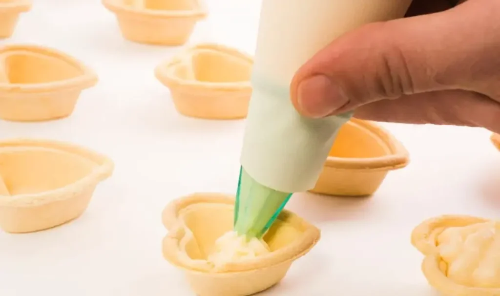 person hand putting white cream heart shape