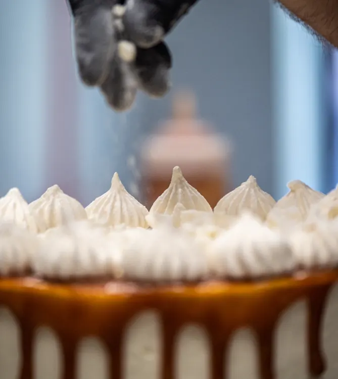 person decorating a cake